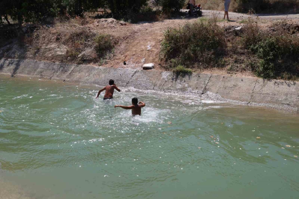 Adana'da gençler sulama kanalında serinlemeye devam ediyor