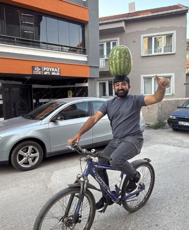 KAFASINDA 40 KİLOLUK KARPUZ VARKEN BİSİKLET SÜRÜYOR, HALAY ÇEKİYOR, KOŞUYA KATILIYOR BETON DÖKERKEN DE HALAY ÇEKERKEN DE KARPUZU KAFASINDAN DÜŞÜRMÜYOR KAFASINDA KARPUZ TAŞIYAN İNŞAAT USTASI MUSTAFA DURMAZ: "KAFAM YA DA BOYNUM ACIMIYOR, BU MESLEK SIRRIDIR EFENDİM"