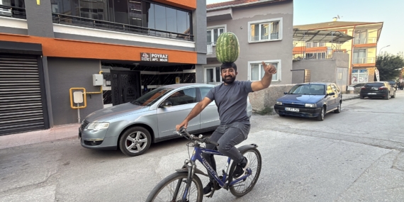 KAFASINDA 40 KİLOLUK KARPUZ VARKEN BİSİKLET SÜRÜYOR, HALAY ÇEKİYOR, KOŞUYA KATILIYOR BETON DÖKERKEN DE HALAY ÇEKERKEN DE KARPUZU KAFASINDAN DÜŞÜRMÜYOR KAFASINDA KARPUZ TAŞIYAN İNŞAAT USTASI MUSTAFA DURMAZ: "KAFAM YA DA BOYNUM ACIMIYOR, BU MESLEK SIRRIDIR EFENDİM"