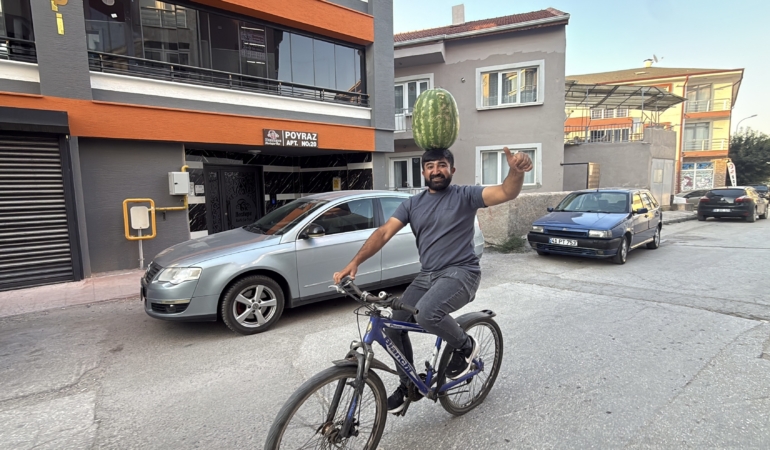 KAFASINDA 40 KİLOLUK KARPUZ VARKEN BİSİKLET SÜRÜYOR, HALAY ÇEKİYOR, KOŞUYA KATILIYOR BETON DÖKERKEN DE HALAY ÇEKERKEN DE KARPUZU KAFASINDAN DÜŞÜRMÜYOR KAFASINDA KARPUZ TAŞIYAN İNŞAAT USTASI MUSTAFA DURMAZ: "KAFAM YA DA BOYNUM ACIMIYOR, BU MESLEK SIRRIDIR EFENDİM"