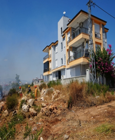 ALEVLER EVLERİN KAPISINA DAYANDI, VATANDAŞLAR HORTUM VE KOVALARLA SEFERBER OLDU YANGIN, İTFAİYE EKİPLERİNİN 1,5 SAATLİK SÖNDÜRME ÇALIŞMASININ ARDINDAN KONTROL ALTINA ALINDI