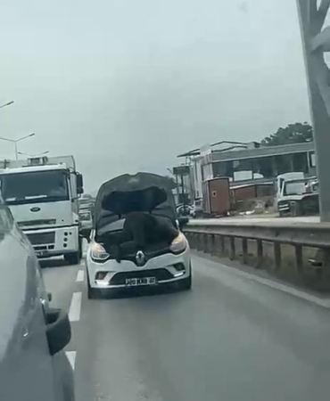 BURSA'DA SEYİR HALİNDEKİ OTOMOBİLİN KAPUTUNU AÇARAK TAMİR YAPTI