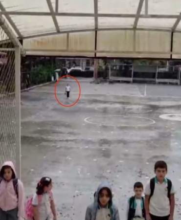 YAĞMUR ALTINDA İSTİKLAL MARŞI OKUYAN İLKOKUL ÖĞRENCİSİ TAKDİR TOPLADI